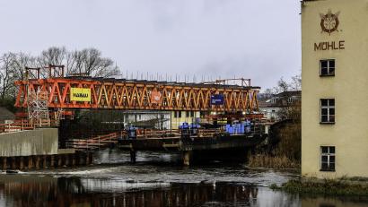 Bild: Hösamer
Ein Traggerüst überspannt derzeit die Naab in Schwandorf zwischen Hubmannwöhrl (links) und Wöhrvorstadt (rechts). An diese Konstruktion wird die Schalung für die neue, kleine Brücke gehängt.