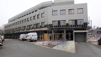 Bild: dwi
Der Anblick des Eingangs in das Gebäude über die Zufahrt Emailfabrikstraße leidet zwar noch an Gerüsten, dafür bietet die Fläche aber Parkplätze und Fahrradständer.