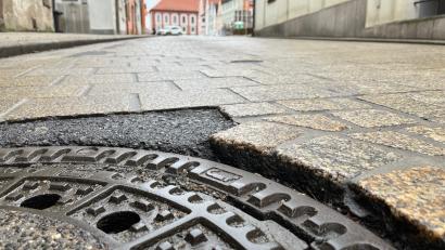 Bild: Gabi Schönberger
Mit Asphalt ist eine der schadhaften Stellen am Pflaster der Zufahrt zum Stadtplatz zwischen Rathaus und dem ehemaligen Uhren- und Schmuckgeschäft Schönweitz in Neustadt ausgebessert.