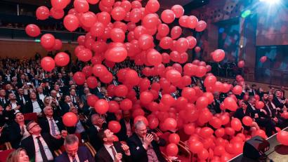 Bild: Stephan Huber
Am Ende des offiziellen Festakts regnete es im großen Saal des ACC rote Luftballons auf die Gäste der Geburtstagsparty der Sparkasse herab.