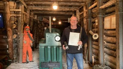 Bild: mzi
Matthias Regn im Auerbacher Schaustollen mit seinem Zeugnis und einer Grubenlampe in der rechten sowie einem Selbstretter in der linken Hand. Die beiden Geräte mussten immer am Mann getragen werden.
