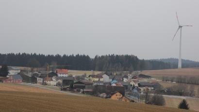 Bild: kro
Asch ist ein günstiger Standort für die Erzeugung von Windenergie. Auf Bärnauer Stadtgebiet wird der Standort bereits genutzt (rechts). In Planung sind nun auch fünf Windräder auf dem Gebiet der Gemeinde Mähring südlich von Asch (links hinten. Der Abstand zu den Häusern soll nach Angaben der Gemeinde mindestens 700 Meter betragen.