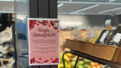 Bild: Raphael Dirnberger
Mit einem Schild wird auf den Sinn der Flirtkörbe aufmerksam gemacht. Wer sich einen pinken Korb nimmt, signalisiert damit "offen für Begegnungen" zu sein.