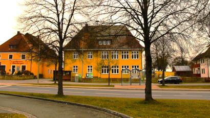 Bild: Krones
Einige Räume im ersten Stock des alten Schulhauses (Mitte) in Großschönbrunn sollen der Rettungsleitstelle, die dahinter neu gebaut wird, zur Verfügung gestellt werden. Streitpunkt sind jedoch die verschiedenen Zufahrtsmöglichkeiten von der Bundesstraße 299 her, links aus südlicher Richtung, rechts vom Norden des Gebäudes her.