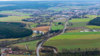 Archivbild: mür
Vom Grenzübergang bei Hundsbach bis zum Stadtgebiet Waldsassen (hinten) verläuft die Bundesstraße 299 schon seit Jahren auf einer neuen Trasse. Für die Fortsetzung im Abschnitt Waldsassen–Kondrau liegt die Baugenehmigung vor, die Freigabe für den Baubeginn aber steht noch aus.