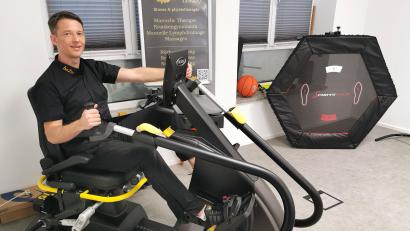 Bild: Portner
Physiotherapeut Henry Seifert zeigt am Ganzkörpertrainer, dass auch Personen mit starken Bewegungseinschränkungen aktiv Muskeln aufbauen können.