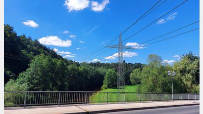 Bildmontage: DB Energie/exb
Diese Visualisierung zeigt eine Bahnstromleitung, die bei einer möglichen Trassenführung zwischen Altenstadt/WN und Neustadt/WN die Waldnaabbrücke überquert.