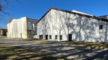 Bild: Stefanie Gradl
5 Millionen Euro investiert die Stadt Vilseck in die neue Ganztagesbetreuung. Der bisherige Trakt der Mehrzweckhalle, in dem die Bühne untergebracht ist, wird abgerissen. Nun gibt es einen neuen großen Anbau mit einer versenkbaren Bühne, damit diese Flächen multifunktional als Betreuungsräume, Küche, Mensa und für Veranstaltungen genutzt werden können. Neben der Dreifach-Sporthalle im Hintergrund wird ein zusätzlicher Eingang in das neue Gebäude errichtet.