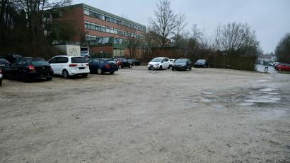 Bild: gsp
Auf diesem Schotter-Parkplatz neben dem Schulgebäude soll das neue Gebäude für den Kfz-Bereich errichtet werden.