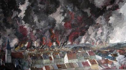Bild: mor
Im Sitzungssaal des Rathauses hängt das Bild „Grafenwöhr in Flammen“. Der geborene Grafenwöhrer Norbert Richter-Scrobinhusen malte es aus dem Gedächtnis. Es zeigt die Ansicht des 8. Aprils 1945 vom Birka aus über die Altstadt zum Lager.