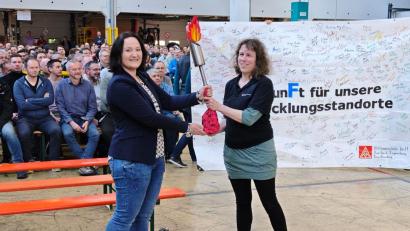 Bild:  Sabine Friede 
Auf der Betriebsversammlungbei ZF in Auerbach übergab die 2. Bevollmächtigte der IG Metall Amberg, Sabrina Feige (links), die Flamme der Solidarität an die Betriebsratsvorsitzende Sonja Hahn.