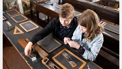 Bild: Stiftlandmuseum/Bewegter Blick/exb
Kinder sind zu einem Mitmachprogramm eingeladen: In der alten Münchenreuther Schule können sie mit Franziska Beck lernen, wie früher mit Tinte, Kreide und Griffel geschrieben wurde.
