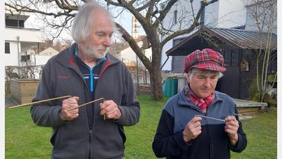 Bild: hka
Willi Meiler und Rita Kordein spüren mit der Wünschelrute ein im Gartenboden verlegtes Kabel auf.