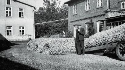Bild: Archiv Fa. Mehler
Firmenbesitzer Ludwig Mehler vor den gefertigten Torpedonetz im Hof der Firma Mehler. In der Folge sollte er sich auch noch zum Spezialisten für Tabakmischungen entwickeln.
