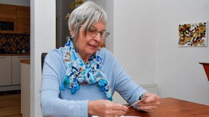 Bild: Petra Hartl
Gaby Wennicke aus Amberg betrachtet alte Fotos, die ihren Vater Hans Kowar und den französischen Geistlichen Henri Cellérier zeigen.