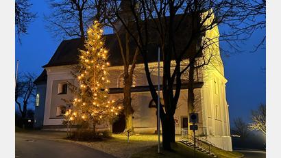 Bild: Pater Stanislaus
Bei einbrechender Dunkelheit leuchten Christbaum und Felixkirche in warmgelbem Licht.