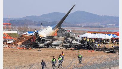 Bild: Ahn Young-joon/AP/dpa
Feuerwehrleute und Rettungskräfte suchen am Wrack des verunglückten Flugzeugs auf dem internationalen Flughafen von Muan nach Opfern.