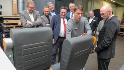 Bild: Wolfgang Steinbacher
Der "Pendulum Seat" für Kurzstrecken-Schienenfahrzeuge ist eine Entwicklung von Probatec. Digitalminister Fabian Mehring (rechts) und weitere Vertreter der Landespolitik fanden das Projekt, das nun einen Partner für die Serienfertigung braucht, spannend.