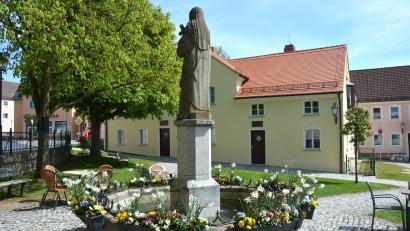 Bild: jr
100 Jahre Heiligsprechung der französischen Heiligen Therese von Lisieux werden in Konnersreuth mit einer zweiwöchigen Veranstaltungsreihe begangen. Im Bild ist der Theresienbrunnen am Therese-Neumann-Platz zu sehen, im Hintergrund das sanierte Reslhaus.