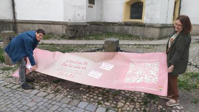 Bild: ald
Susanne Götte (links) und Pfarrerin Christiane Weber bei den letzten Vorbereitungen: Ein großes Plakat vor der Kirche St. Michael in Weiden soll Fußgänger auf die Aktion "Einfach heiraten" aufmerksam machen.