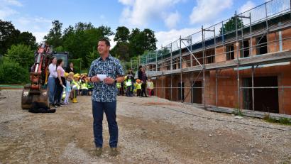 Bild: hdk
Bürgermeister Jörk Kaduk bei seiner Begrüßungsrede vor dem Rohbau. Die Kindergartenkindern (im Hintergrund) sangen zur Feier des Tages das Lied "Wer will fleißige Handwerker sehen".