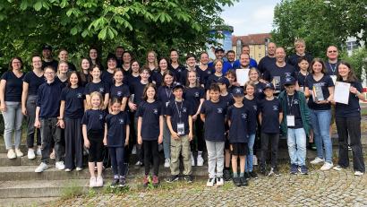 Bild: Anna Waldherr
Die beiden frischgebackenen Siegerteams vom Kolping-Spielmannszug freuen sich über ihre Erfolge bei der Deutschen Meisterschaft 2025 in Ulm. Dirigent Reinhard Lößl und Dirigentin Judith Schneeberger präsentieren die Siegestrophäen.