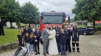 Bild: Mirijam Schuller
Das frisch vermählte Brautpaar mit den Gratulanten der Freiwilligen Feuerwehr Waidhaus
