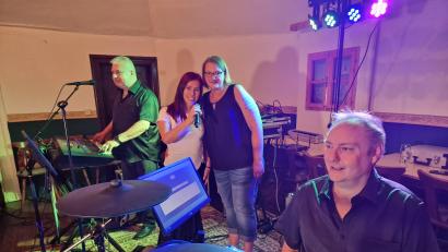 Bild: R. Kreuzer
Jasmin Ludewig (Mitte) neben Sängerin Nadja Sommer, dahinter am Keyboard Georg Schachtel, dankt der Partyband „Perfect“ um Markus Roth (rechts am Schlagzeug) für das Benefizkonzert im Postkeller. Der Erlös von 1.400 Euro geht an ihre Krebstherapie.