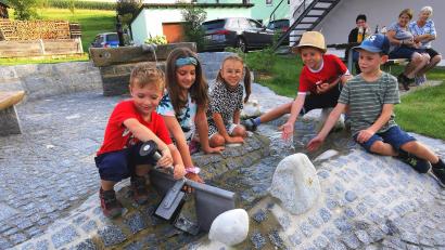 Archivbild: Portner
Die Kinder von Oberlangau haben Spaß an der Staustufe im neuen "Hundertwasser-Style"-Bachlauf. Mit ILE-Mitteln kann noch in 2025 eine überdachte Sitzgarnitur aufgestellt werden.