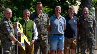 Bild: Soldaten- und Reservistenkameradschaft Pirk
Die Gemeinde Pirk hat eine gelbe Schleife als Zeichen der Verbundenheit erhalten (v.l.): Major Lars P. (Batteriechef der 4./PzArtBtl375), Dietmar Schaller (Bürgermeister Pirk), Stabsfeldwebel Schleicher (Deutscher Bundeswehrverband), Mario Hönig (Vorstand Soldaten u. Reservistenkameradschaft Pirk), Tobias Forster (2.BGM Pirk), Oberstabsfeldwebel Michael Z. (Sieß 4./375).