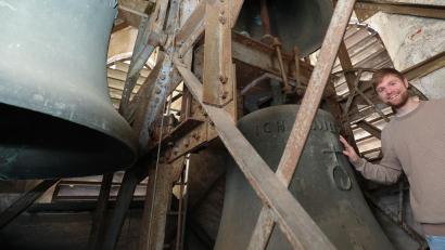 Bild: Wolfgang Steinbacher
Daniel Götzfried steht im Kirchturm und hält seine Hand auf die über eine Tonne schwere Glocke, die bald ausgetauscht wird. Seit sechs Jahren ertönt nur noch das Stundengeläut, ansonsten Schweigen die Glocken aus Sicherheitsgründen.