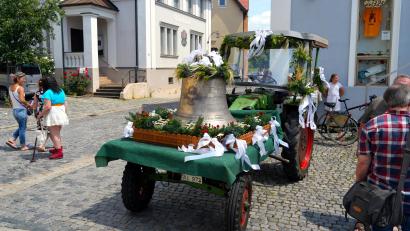 Bild: gac
Die neue Taufglocke mit dem festlich geschmückten Bulldog auf dem Rosenberger Dorfplatz.