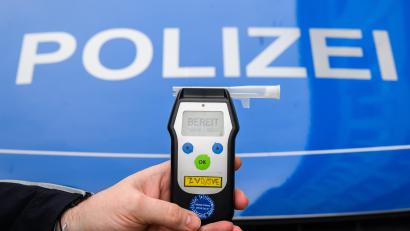 Symbolbild: Julian Stratenschulte
Ein Polizist zeigt einen Alkoholtest.
