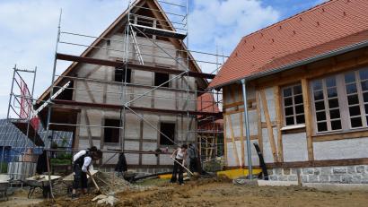 Archivbild: szl
So sah die Naturdorf-Baustelle im Juni vergangenen Jahres aus. Zwei Wochen lang machten damals Wandergesellen verschiedenster Gewerke einen Anfang bei der Gestaltung der Außenanlagen. Im September sollen nun die ersten beiden Ferienhäuser beziehbar sein.
