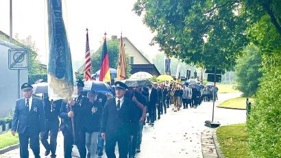 Bild: Gerhard Krones
Der Kirchenzug machte sich bei strömenden Regen auf den Weg Richtung Kirche. Regenschirme halfen nur bedingt und viele Teilnehmer kamen durchnässt dort an.