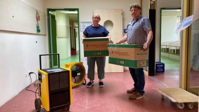 Bild: Völkl
Kindergartenleiterin Dana Graf und Zweiter Bürgermeister Andreas Altmann packen an: Material und Spielsachen werden in Umzugskartons zwischengelagert. Lüftungsgeräte ziehen die Feuchte aus den Räumen.