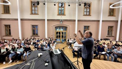Bild: upl
Bernhard Müllers in seinem Element. Der Amberger ist einer von drei Dirigenten, die den Mega-Chor in der Olympiahalle leiten.