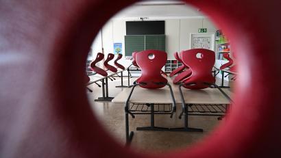 Symbolbild: Bernd Weißbrod /dpa
Stühle stehen in einem leeren Klassenzimmer. Bei einer Klassenfahrt fällt ein Lehrer aus Amberg mit einem Stoffbeutel eines rechtsextremen Unternehmens auf. Der Fall landet daraufhin beim Kultusministerium.