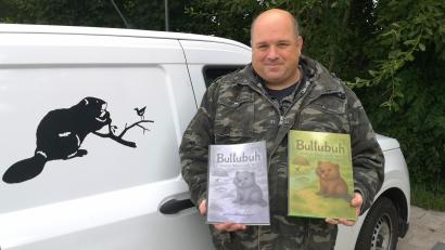 Bild: lnz
Biberberater Horst Fischer aus Mitterteich hat ein erstes Kinderbuch herausgebracht und plant weitere Bände. Hier steht er neben seinem Auto mit Biberlogo und präsentiert zwei Versionen des Werks "Bullubuh - kleiner Biber, große Welt".