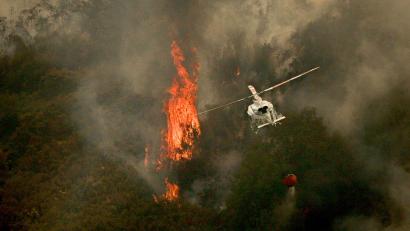 Bild: Adrián Irago/EUROPA PRESS/dpa
Ein Löschhubschrauber wirft Wasser über einem Feuer in der spanischen Provinz Ourense ab.