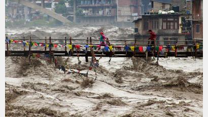 Bild: Aqil Khan/AP/dpa
Menschen wagen im nordindischen Bundesstaat Himachal Pradesh trotz schwerer Überschwemmungen den Weg über eine Brücke, um den Fluss Beas zu überqueren.