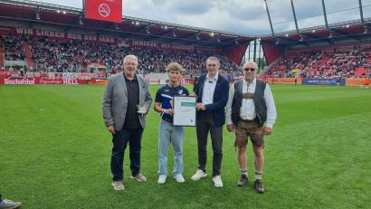 Bild: Christian Fuchs/BFV
BFV-Vizepräsident Jürgen Pfau (Zweiter von rechts) und Bezirksvorsitzender Thomas Graml (links) ehrten Joseph Renner (Zweiter von links). Christian Büchner (rechts) war damals Schiedsrichter der Partie zwischen Stadtamhof und Bernhardswald.