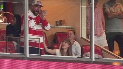 Bild: Charlie Riedel/AP/dpa
Er jubelt, sie wirft ihm einen verliebten Blick zu: Travis Kelce und Taylor Swift bei einem College-Football-Spiel.