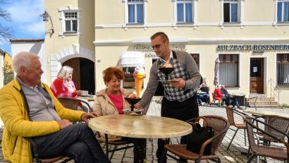 Archivbild: Petra Hartl
Da war die Stimmung noch gut: Mario de Marco bedient im Frühjahr 2023 Kunden in seinem Eiscafé Sommariva. Kurz danach gingen die Bauarbeiten an der Fassade der Marienkirche los. Das habe ihn über die Jahre so belastet, dass leider auch der Service gelitten habe.