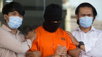Bild: Firdia Lisnawati/AP/dpa
Der Verdächtige wurde nach seiner Festnahme im Mai in einem orangen Sträflingsanzug der Presse vorgeführt.