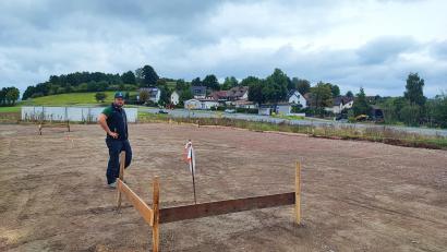 Bild: luk
Schnüre markieren den Platz für das künftige Verwaltungsgebäude von Matthias Langs Garten- und Landschaftsbaufirma. Anfang Oktober soll die Bodenplatte gegossen werden. Im Hintergrund sind die Staatsstraße 2665 und die Ortschaft Löschwitz zu sehen.