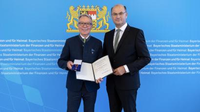 Bild: StMFH/Christian Blaschka
Finanz- und Heimatminister Albert Füracker überreicht das Verdienstkreuz am Bande an Reinhold Wildenauer.