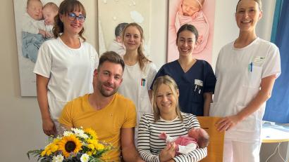 Bild: Kliniken Nordoberpfalz AG
Milena und Stefan Plößner freuen sich über die Geburt ihrer Tochter Emily. Oberärztin Dr. Sophie Heine (hinten, rechts), Hebamme Julia Volkmer, PA Katharina Käs und Pflegekraft Bianca Weiß gratulieren.