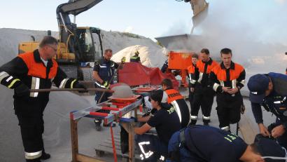 Bild: ge
Übung für den Ernstfall: Vorne werden die Sandsäcke nach herkömmlicher Methode per Schaufel und Trichter gefüllt, hinten schüttet der Bagger Nachschub in die Sandsackmaschine.