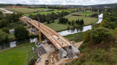 Bild: hbe
Die neue Vilsbrücke bei Theuern, die größte der acht Brücken der Kümmersbrucker Westumgehung, nimmt Gestalt an. Links hinten im Bild beginnt die Umgehungsstraße nahe der Autobahnauffahrt Amberg-Süd, führt dann über die Brücke und (im rechten unteren Drittel des Bildes) weiter Richtung Grammer/Haselmühl.